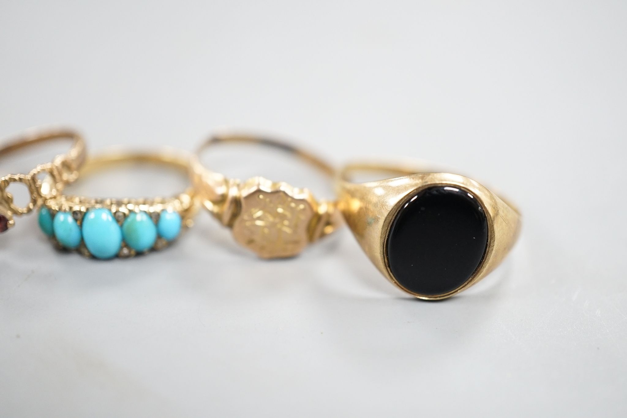 Four assorted 9ct rings including serpent(tired), signet and two gem set gross 10 grams and a yellow metal and five stone turquoise set ring, gross 3.6 grams.